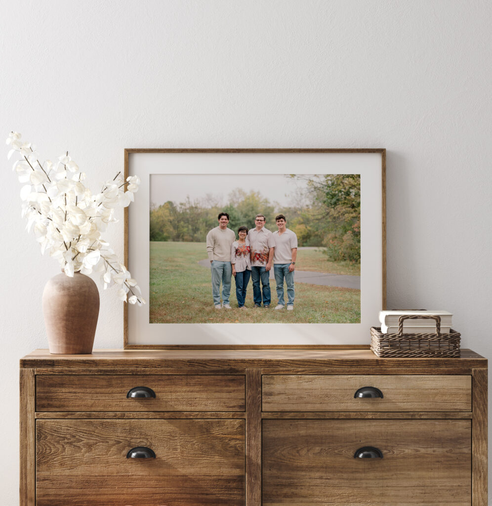 Image of a large framed print on a dresser of a family outside during the fall.