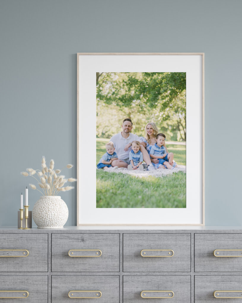 Image of a family sitting outside during a summer session with their two small kids.